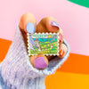 Hand Holding The Valley of the Wind Enamel Pin