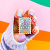 Hand Holding Arenfjord Enamel Pin with colored nails