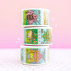 Paper Washi Tape Rolls stacked. Features Japanese Anime Stamp designs: Porthaven, Forest Spirits, The Bathhouse. With gel pen and crafting scissors on plain background.