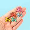 Hand holding Balloon Dog Enamel Pins in Yellow, Teal, Blue, Pink and Red