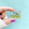 Hand holding Anne of Green Gables Stamp Enamel Pin by Lucy by Maud Montgomery