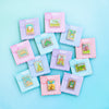 Colorful Display of Mix and Match Stamp Enamel Pin Set, Porthaven, Neverland, A Galaxy Far Far Away, Tulgey Woods, The Magical Castle for Wizards, Pemberley, Wizard of Oz, The Safari Dinosaur Island, The Wardrobe, Bag End, Dune, Anne of Green Gables