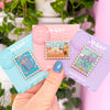 Hand holding stamp enamel pins The Police Box, arenfjord, desert planet