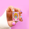 Hand holding a atamp Enamel Pin of Princess Castle, a Magical Mirror and rose